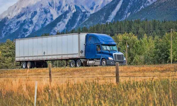 tractor trailer driving down scenic highway