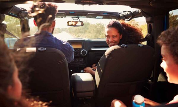 family on road trip sitting and laughing in car