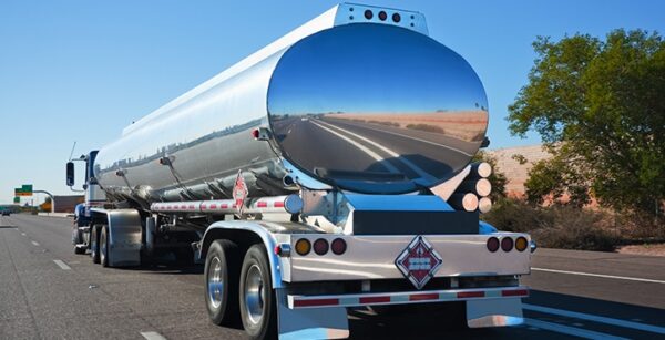 Rear view of a tanker truck driving along road