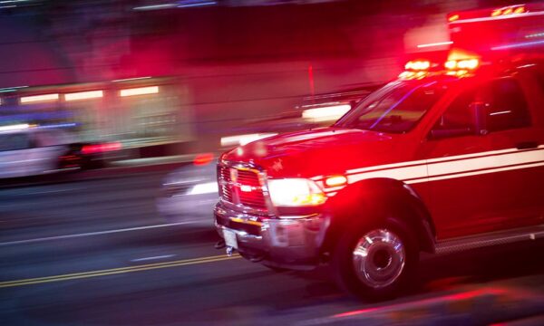 ambulance driving down a street with flashers on