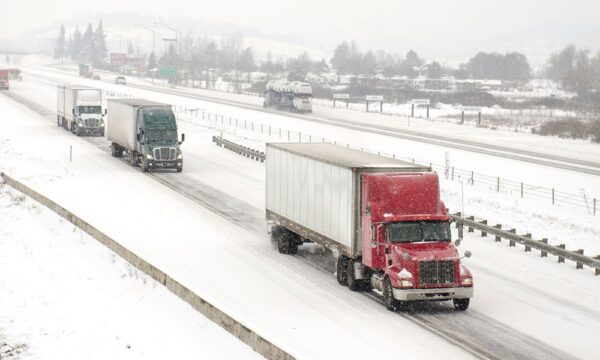 truck driving  on a highway through a snow storm