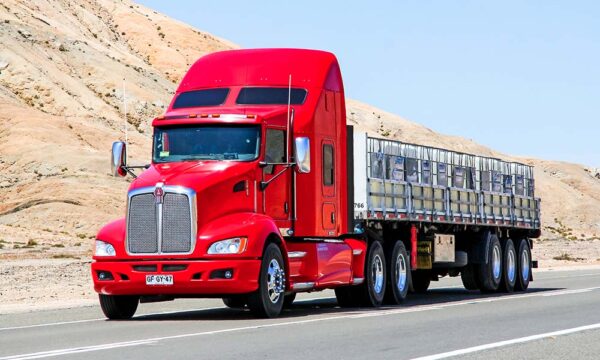 red tractor trailer driving down highway