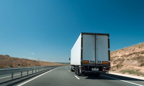 rear of a tractor trailer driving down highway