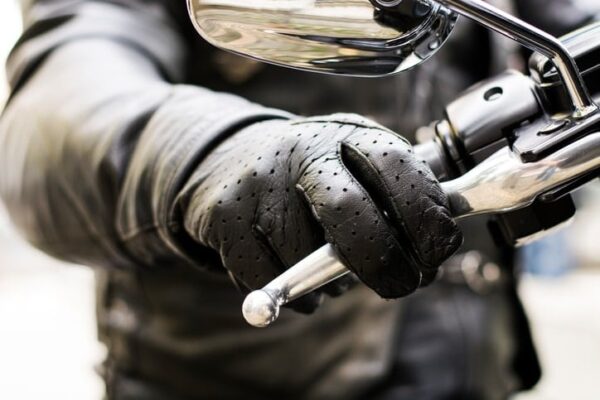 Closeup of a gloved hand holding a motorcycle handle