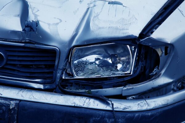 Image of silver car with smashed front bumper and grill