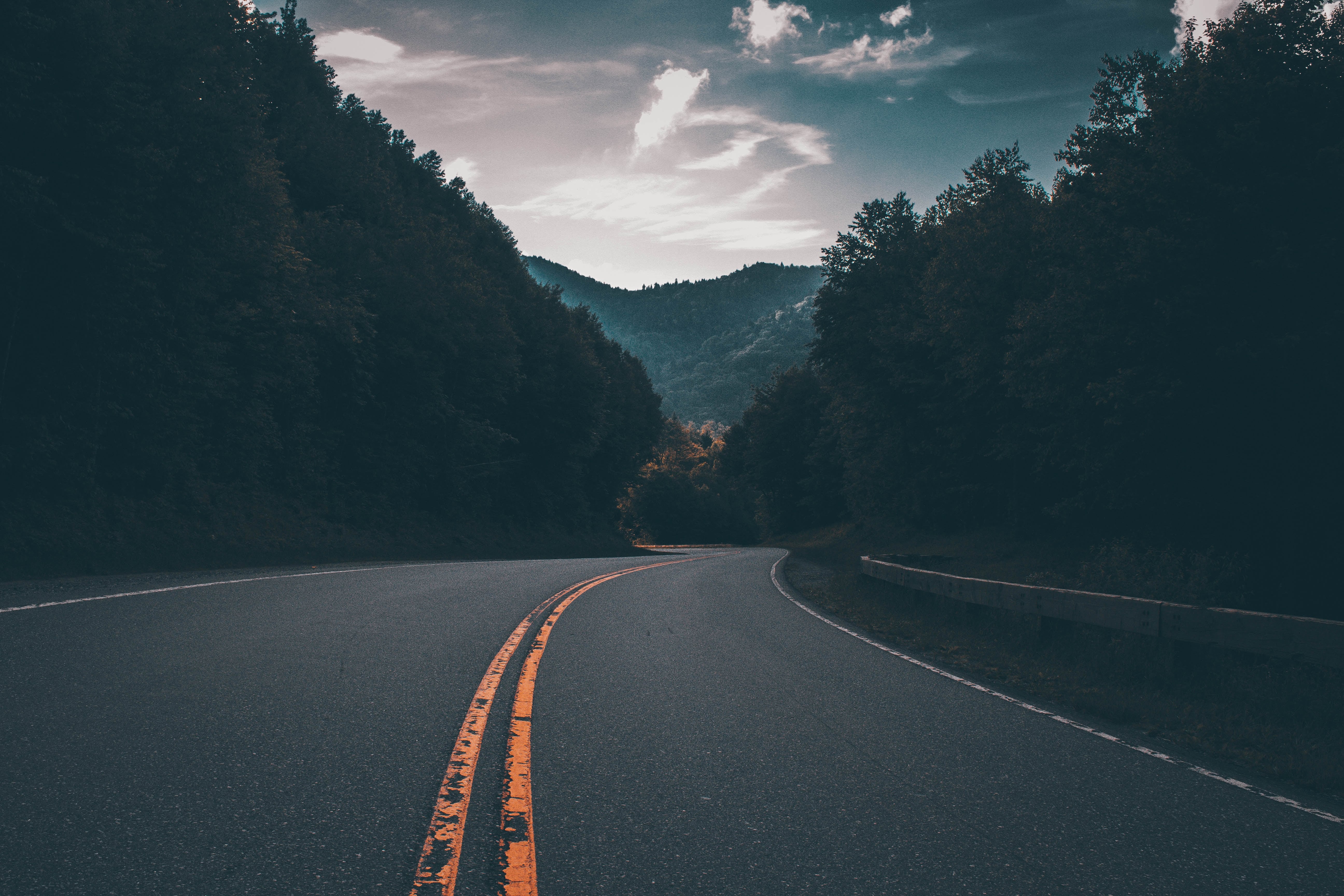 Winding highway road leading up to mountains at dusk