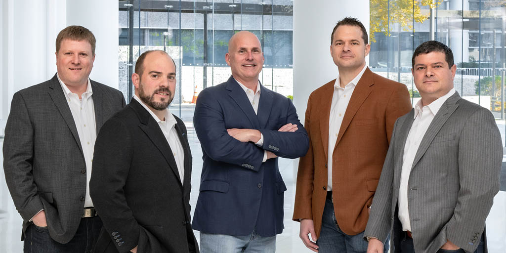 Group photo of Fried Goldberg attorney team set against office background