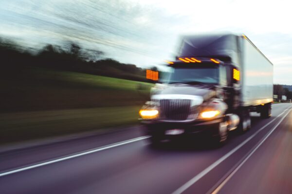 Black big rig traveling head-on blurred due to high speed
