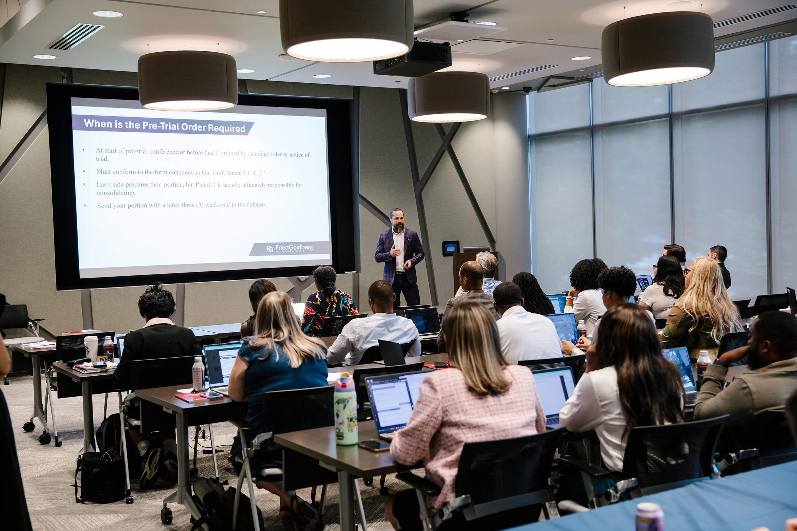 Audience listens to a pre-trial order presentation at Clinic 2025.
