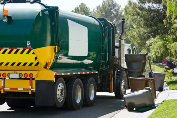 Garbage truck picking up trash bins from residential area