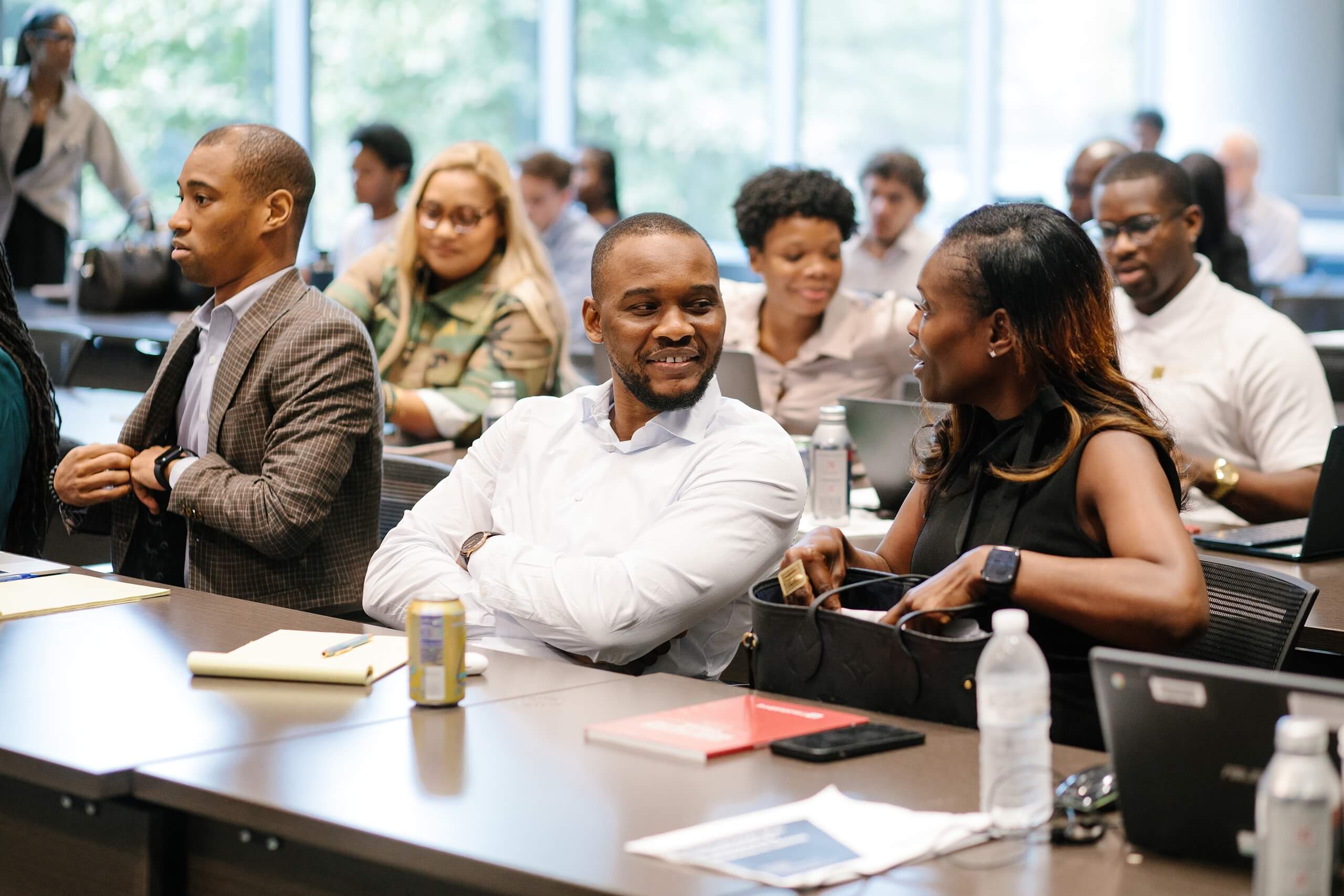 Participants seated at tables talk and review materials during the Trial Skills Clinic 2025.