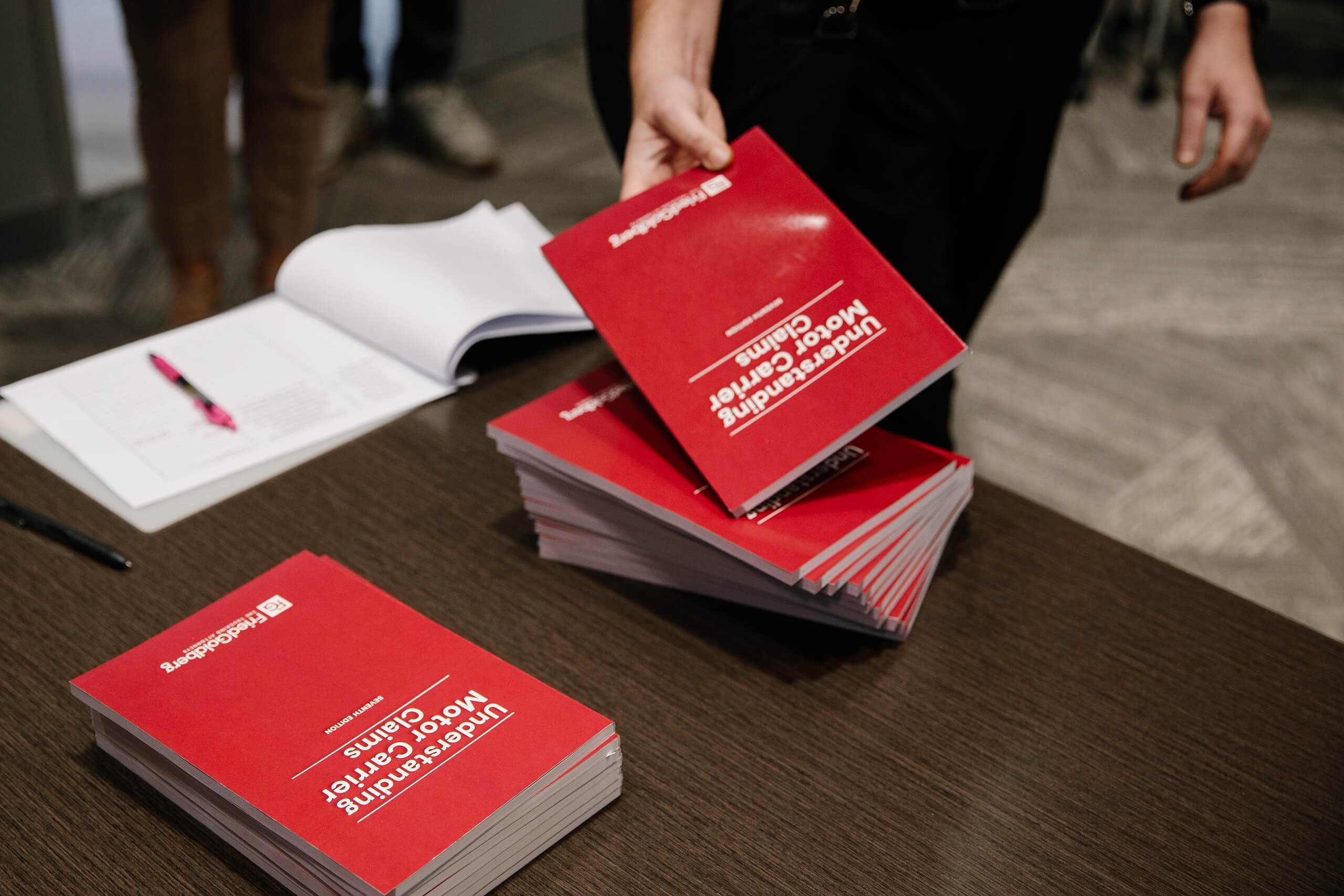 A closeup view of red Fried Goldberg booklets distributed at the Trial Skills Clinic 2025.