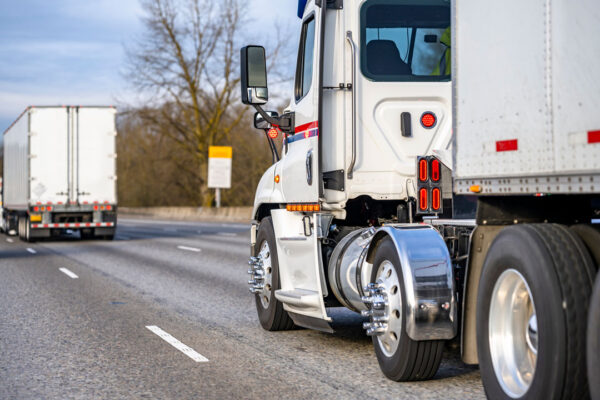 Side view of a tractor trailer driving down highway